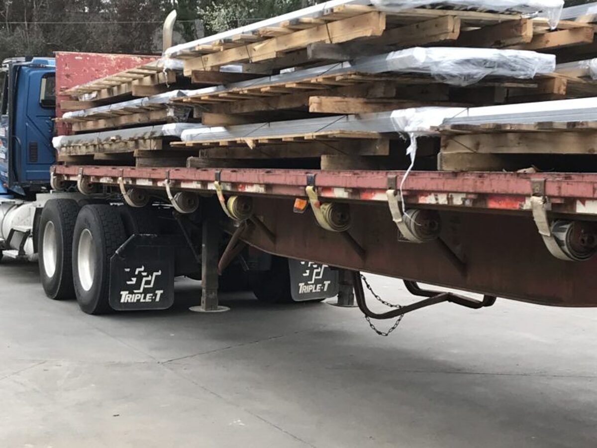 Heavy-gauge profiles loaded and banded on a flatbed trailer for delivery